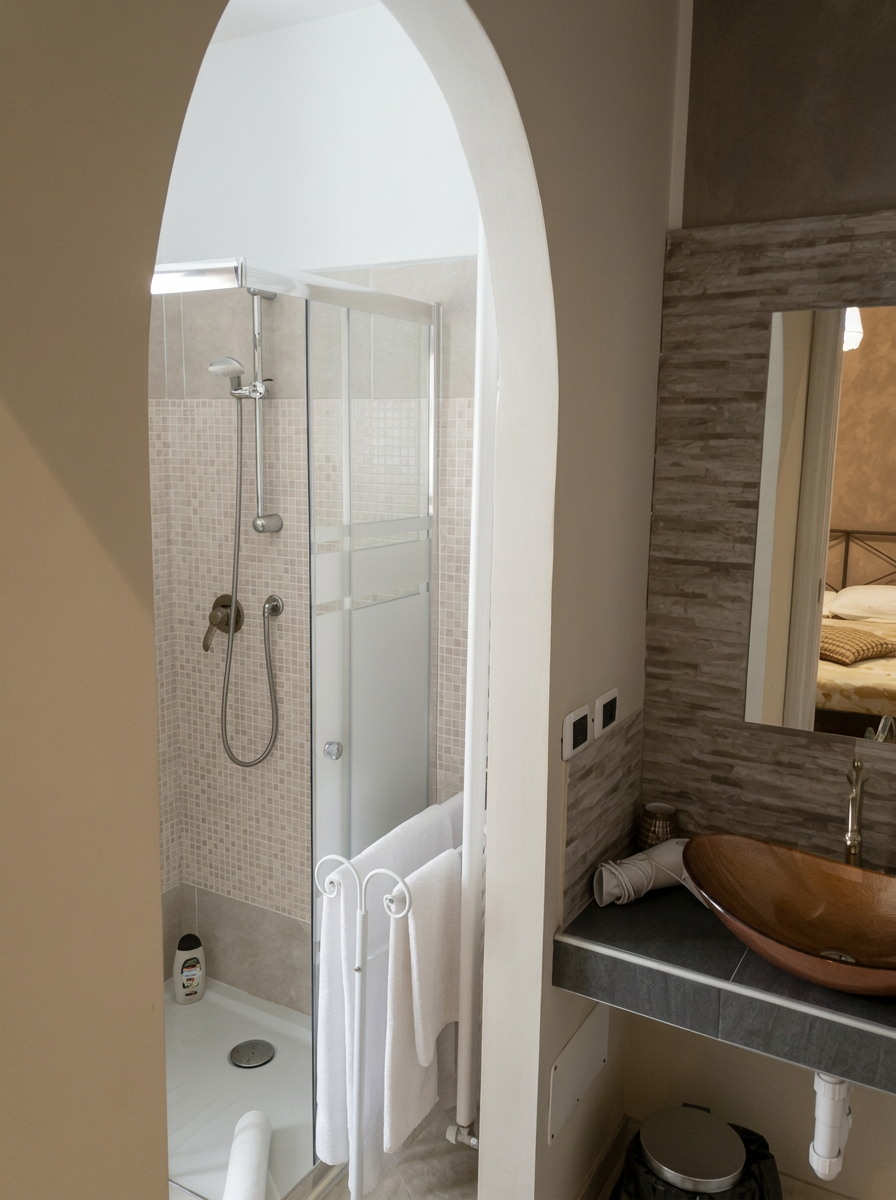 Bagno con doccia in vetro e lavabo a ciotola